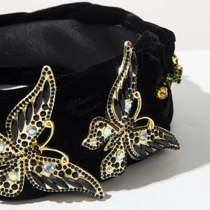 Détail du serre-tête en velours avec bijoux papillons complexes et strass AB étincelants
