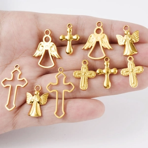 Golden 304 stainless steel angel and cross pendant charms shown in hand for size context