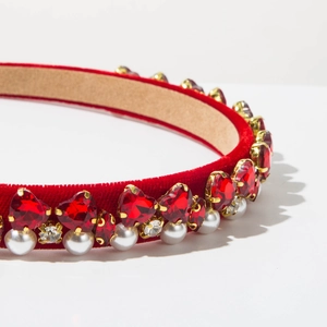 Detail of red velvet headband with heart crystals, white pearls and sparkling rhinestones