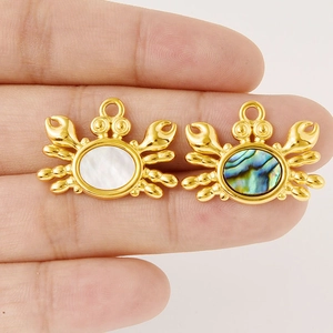 Vue détaillée de pendentifs crabe dorés avec incrustation de nacre naturelle