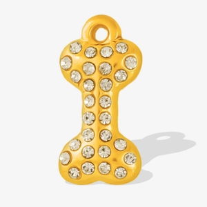 Detail of gold bone pendant with white rhinestones and a hanging hole for jewelry DIY