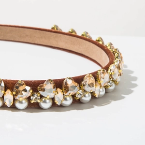 Detailed macro shot of brown velvet headband with heart crystals and white pearls