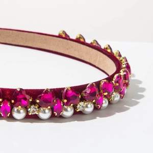 Detailed view of red velvet headband featuring pearls and pink heart crystals