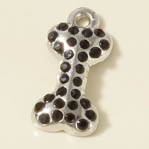Macro detail of bone-shaped pendant with black pavé crystals on stainless steel base