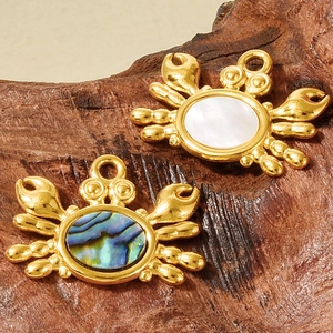 Détails macro de pendentifs crabe en or avec incrustations de nacre et de coquille d'abalone