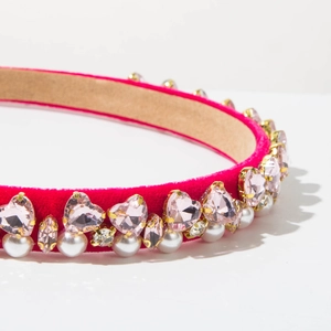 Detailed close-up of pink velvet headband with crystal hearts and pearl embellishments
