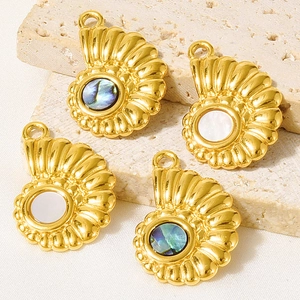 Vue macro de pendentifs coquillages dorés avec incrustations de nacre et d'abalone