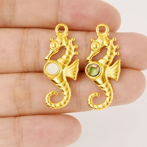 Détail macro de pendentifs hippocampe avec incrustations de nacre et placage doré