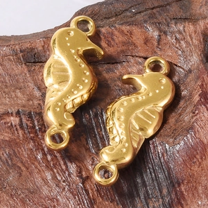Set Seepferdchen-Schmuckanhänger aus 304 Edelstahl in Gold auf rustikaler Holzoberfläche