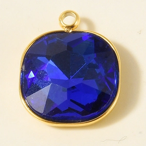 Detailed view of square blue faceted glass pendant with 18k gold plated steel frame