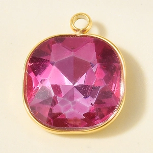 Close-up of pink cushion-cut gemstone pendant with polished gold stainless steel frame