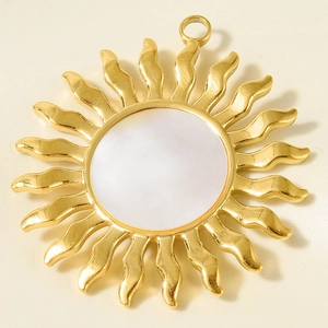 Vue détaillée du pendentif soleil doré avec rayons ondulés et incrustation de nacre