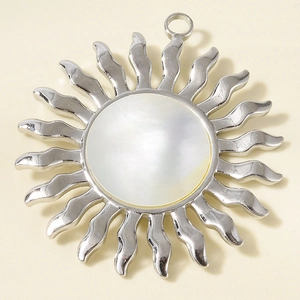 Détail macro du pendentif soleil en acier 304 avec incrustation en nacre blanche