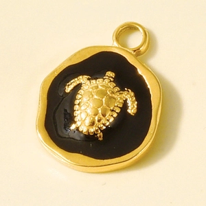 Detail of a vintage 304 stainless steel sea turtle pendant with gold trim and black oil drip