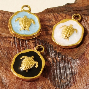 Detail view of 304 stainless steel turtle pendants with colorful enamel on wood surface