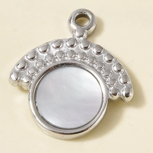 Macro detail of 304 stainless steel pendant with white mother of pearl inlay and embossed texture