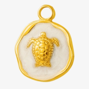 Close-up of golden turtle relief pendant with white enamel background and irregular edge