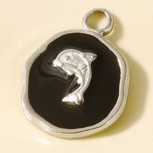 Vue macro d'un dauphin argenté sur pendentif en émail noir pour bijoux DIY
