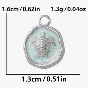Macro view of blue enamel sea turtle pendant with size measurements 1.6cm by 1.3cm