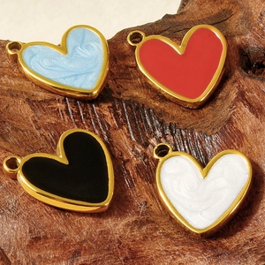 Macro detail of heart-shaped enamel charms in four colors for DIY jewelry making