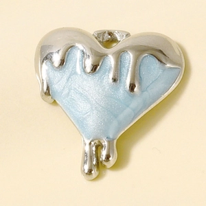 Macro detail of heart-shaped pendant with melting silver edges and blue glitter drip