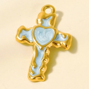 Macro detail of a 304 stainless steel cross pendant with light blue enamel and a heart