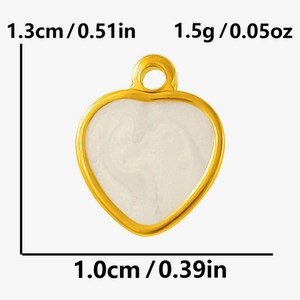 Macro detail of heart charm with gold border and white enamel including dimensions