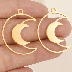 Detailansicht goldener hohler Mondanhänger für DIY Schmuckherstellung auf Hand