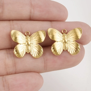 Dettaglio macro di ciondoli a farfalla dorati con texture fine e anelli per gioielli DIY