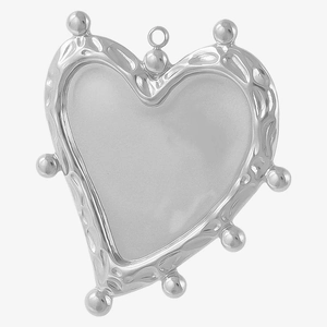 Macro detail of silver-tone hammered heart pendant with decorative metal beads and bail