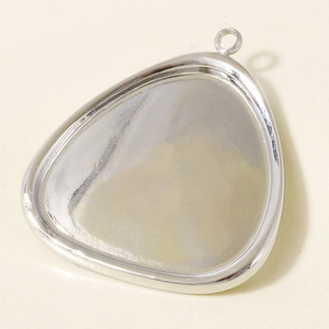 Close-up of polished silver teardrop pendant bezel with hanging loop for DIY jewelry