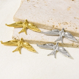 Detail of bird charms in gold and silver finish with detailed feather textures