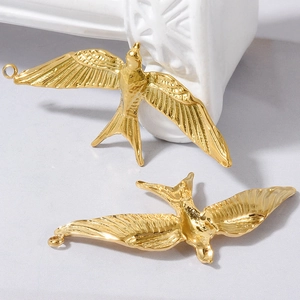 Macro detail of 304 stainless steel bird pendants in gold plating with wing textures