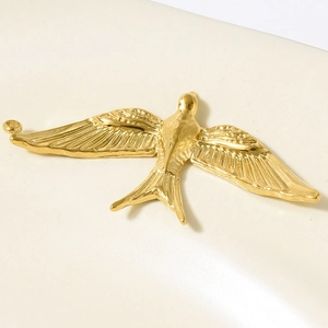 Detailed macro shot of 18k gold swallow bird pendant with intricate feather textures