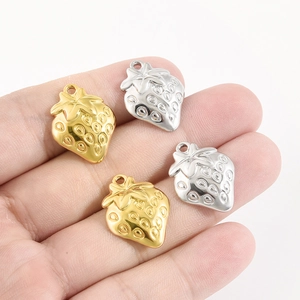Détail macro de pendentifs fraises en finitions polies dorées et argentées