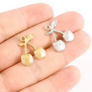 Gros plan détaillé des breloques cerise pour colliers DIY en finition or et argent