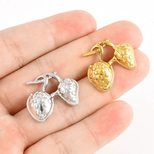 Gros plan de pendentifs fraises en acier inoxydable 304 en finitions or et argent