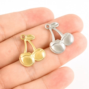 Détail macro de pendentifs cerises en or et argent pour la création de bijoux DIY