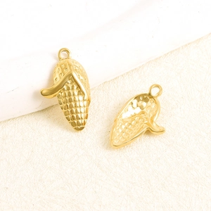 Gros plan détaillé de breloques maïs dorées montrant la texture pour bijoux DIY