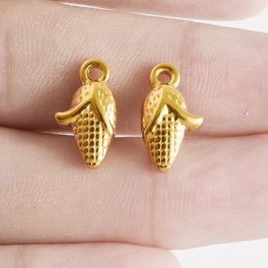 Vue macro de breloques en forme de maïs doré pour bijoux DIY avec texture détaillée