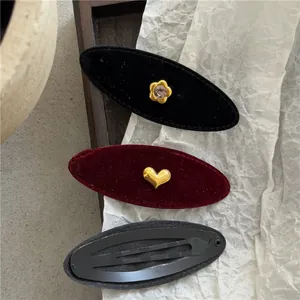 Detail of vintage velvet hair clips with golden heart and rhinestone flower accents
