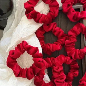 Elegant red velvet scrunchies for hair styling shown on white and dark background