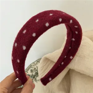 Dettaglio di fascia per capelli in feltro bordeaux a pois bianchi stile autunno inverno