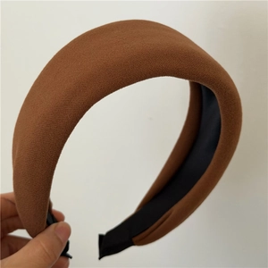 Détail d'un serre-tête épais en tissu marron avec une texture tricotée et rembourrage