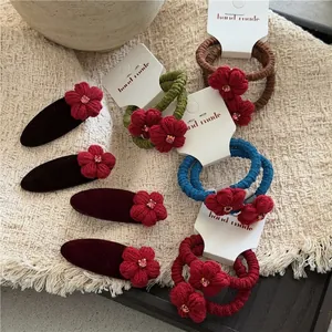 Rote gehäkelte Blumen-Haarklammern und elastische Haarbänder mit rosa Strasssteinen