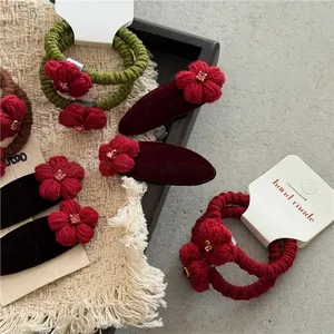 Handgefertigte rote Strass-Stoffblumen Haargummis und Samt-Clips auf rustikalem Display