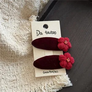 Details von roten Samt-Haarspangen mit handgefertigten Blumen und Glitzersteinen