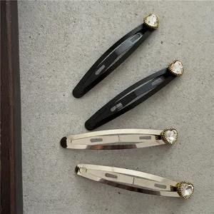 Detalle de cuatro pinzas de metal para el pelo con diamantes de imitación de corazón en plata