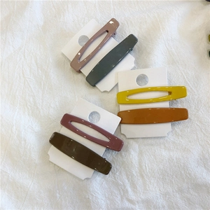 Close-up of geometric hollow and solid matte acrylic hair clips in Morandi colors
