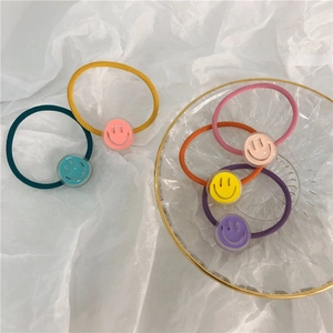 Close-up of five colorful elastic hair ties with cute transparent smiley face beads